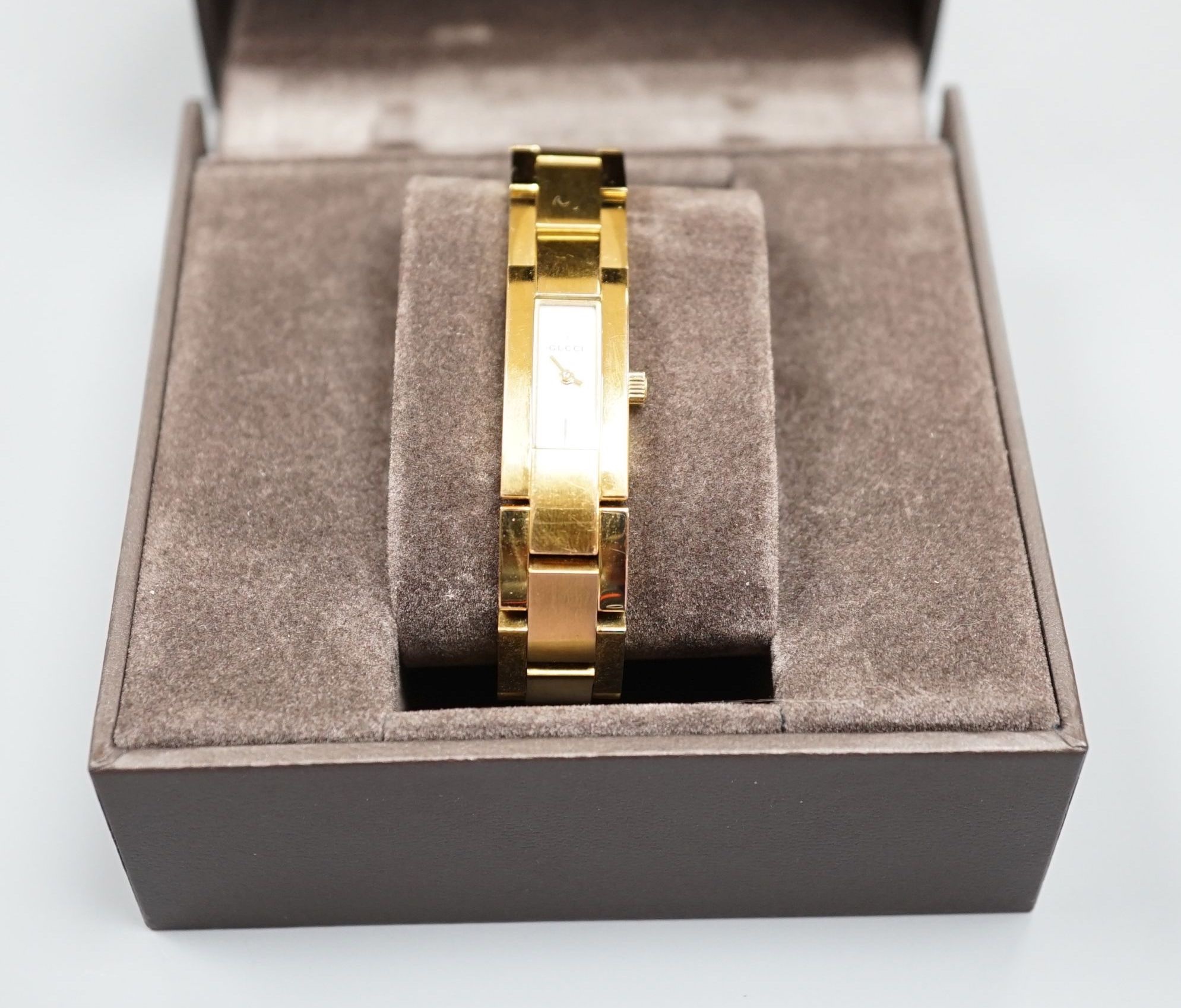 A modern pair of silver 'Concorde' napkin rings, together with a lady's gilded stainless steel Gucci quartz wrist watch with box, no papers.